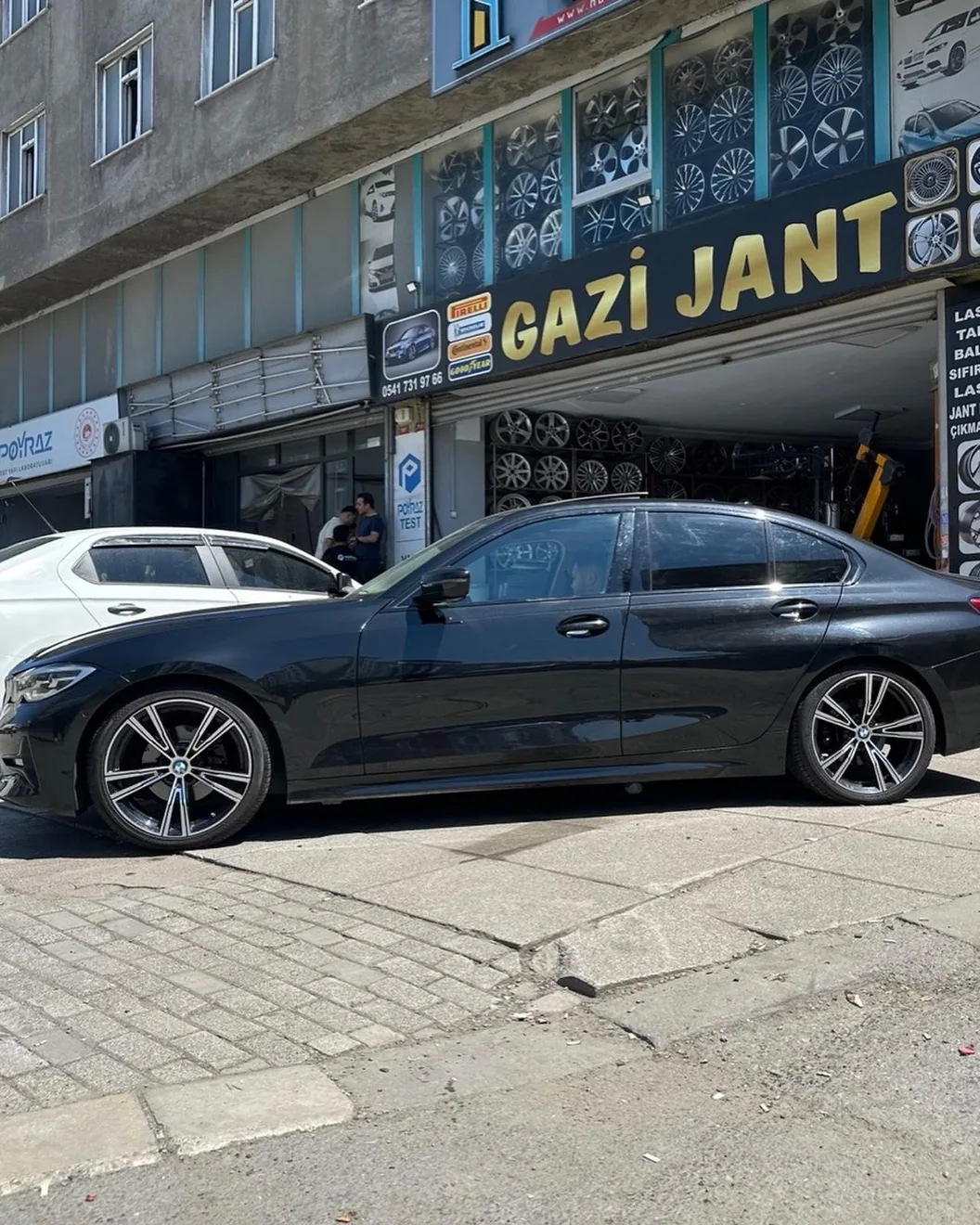 Siyah araç önünde Gazi Jant mağazası